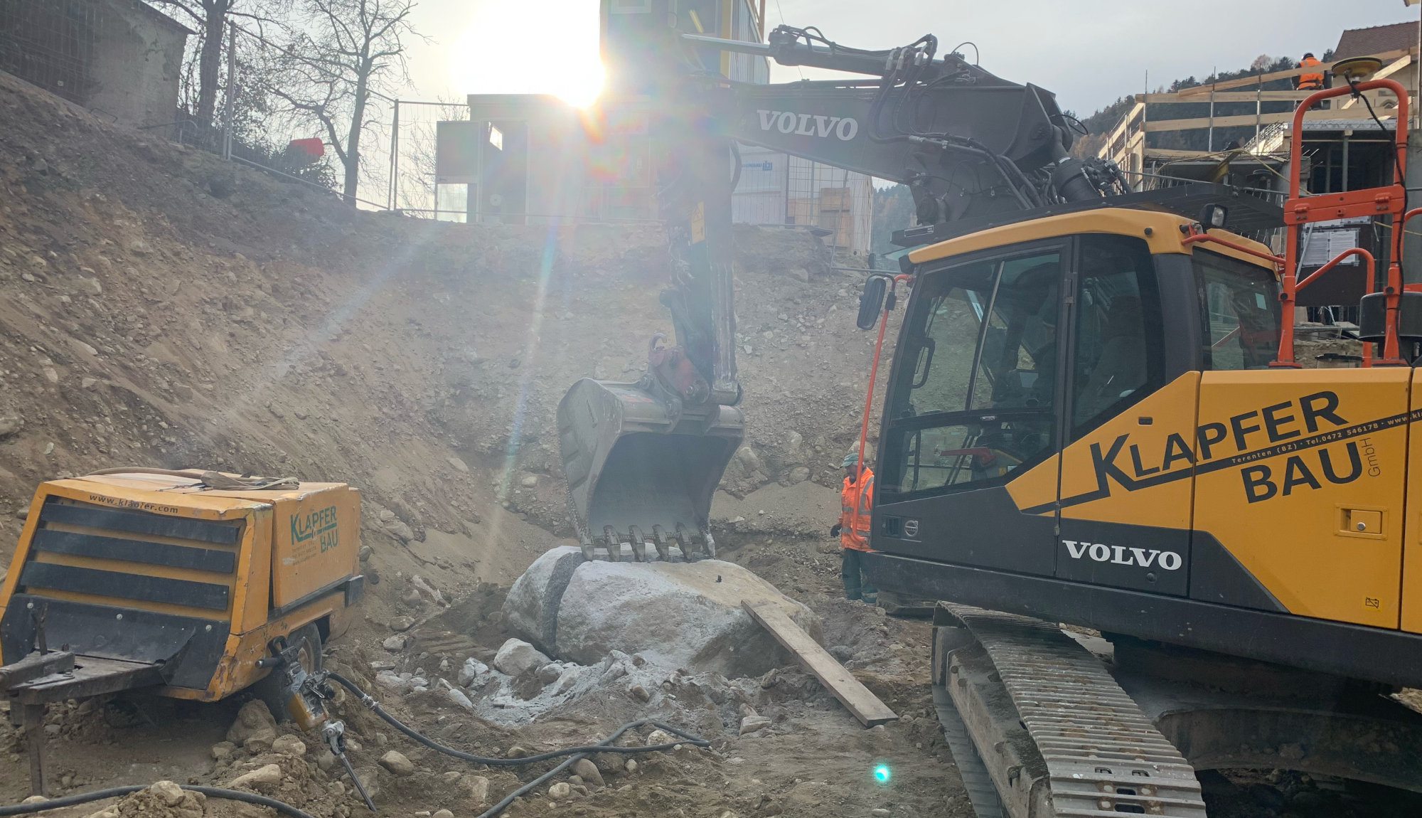 Klapfer Bau - Leistungen - Tiefbau - Slider - Bagger mit Sonnenstrahlen